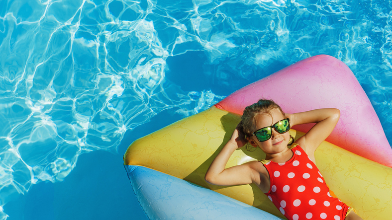 Child in swimming pool. Having fun on vacation at the pool.